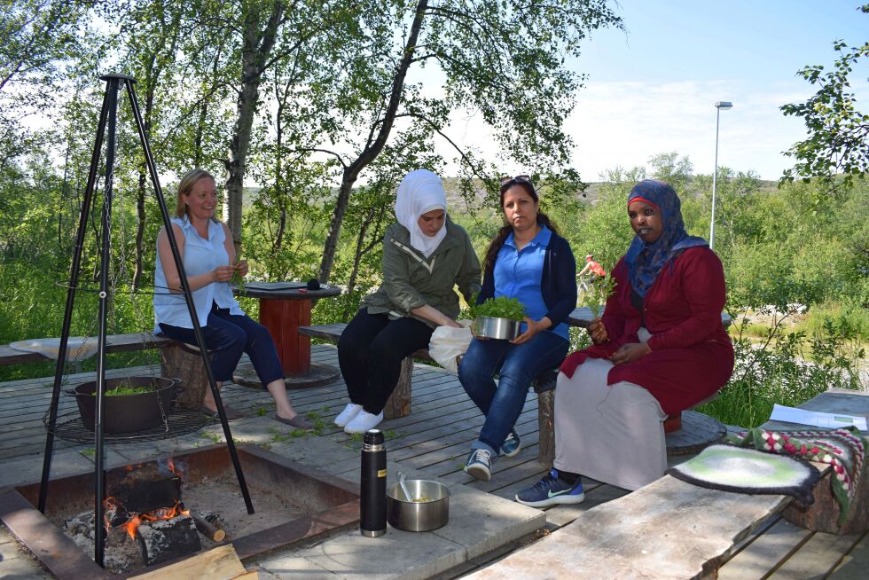 Stine Seipæjærvi, Najlaa Omar, Jihah Qlaji og Fario Muhammed koser seg på bålplassen ved Førstevann like utenfor Kirkenes.
 Foto: Birgitte Wisur Olsen