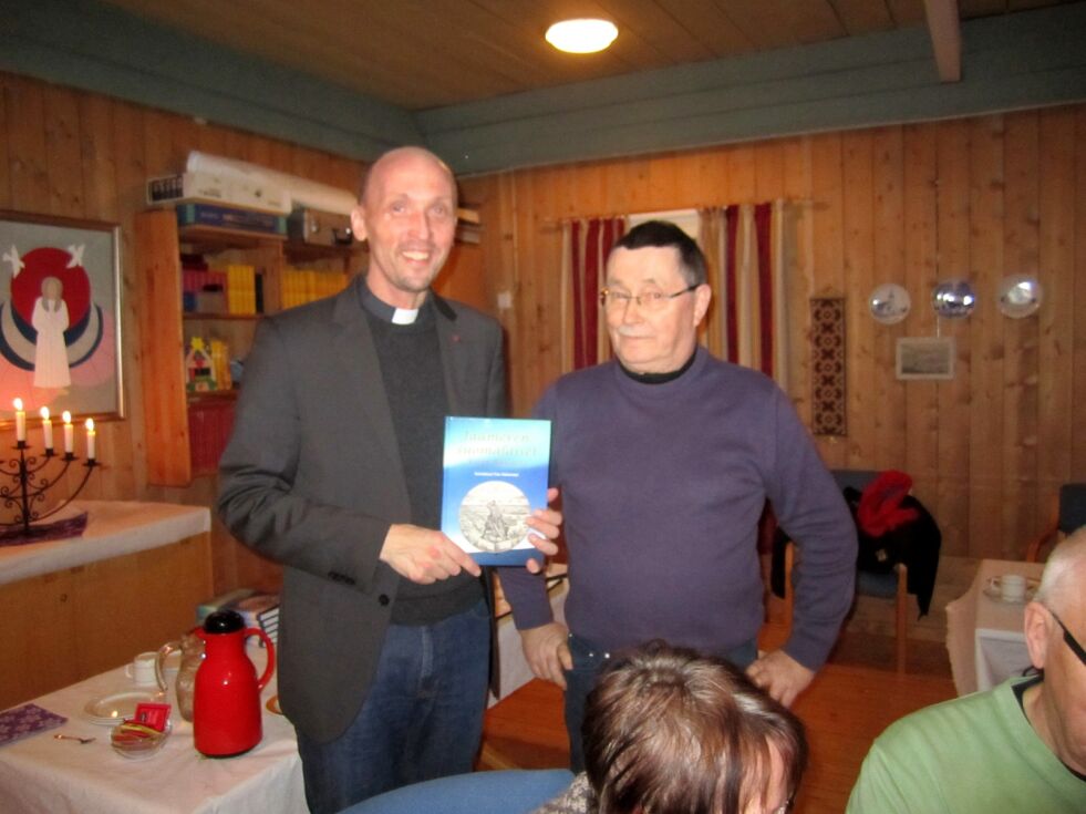 Leder for Porsanger Norsk-finsk forening, Odd Ragnar Olsen (til høyre) overrakte den besøkende prest Anssi Elenius boka «Den finske arven».
 Foto: Olavi Hoikka