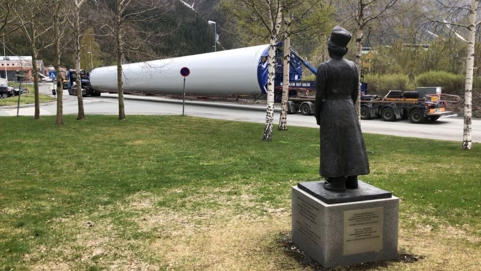 Illustrasjonsfoto viser transport av en lengde turbintårn som skal til Øyfjellet vindindustriområde. Her passerer man Vefsn rådhus og statuen av Elsa Laula Renberg.
 Foto: Motvind Bevar Øyfjellet