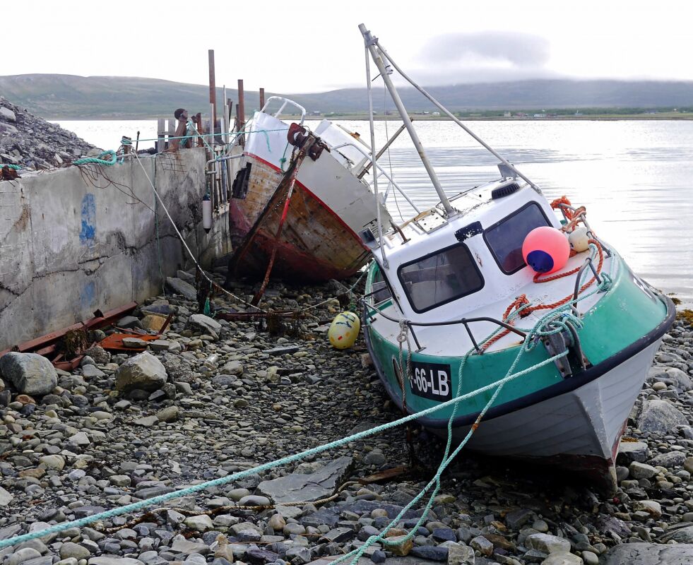 Fiskebåter som ikke lenger er i bruk, er dratt opp på land, og har blitt liggende i havna på Veidnes.
 Foto: Geir Johansen