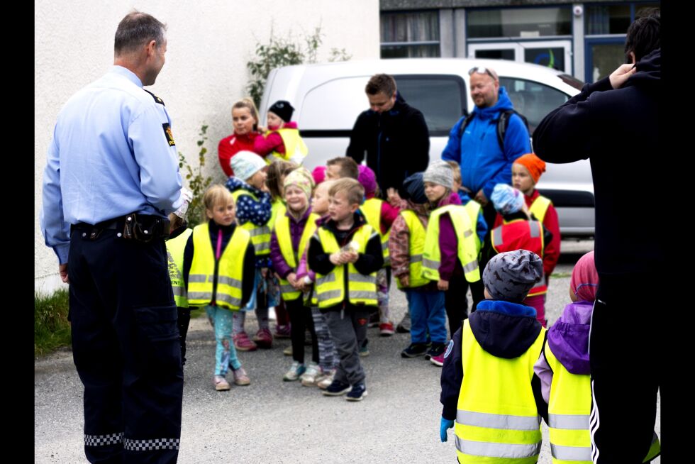 Politibetjent Frank Nilsen forteller barna litt om hvem politiet er, og hva de gjør. Snart skal barna få lov å sitte i politibilen.
 Foto: June Helén Bjørnback