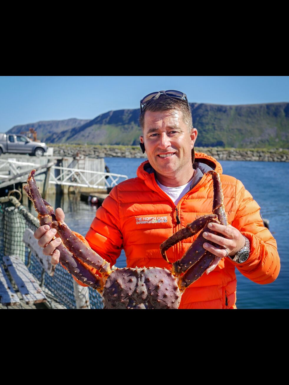 Kongekrabben, som Jonathan Dillon her holder et eksemplar av, har blitt til rene turistmagneten i Skarsvåg.
 Foto: Geir Johansen