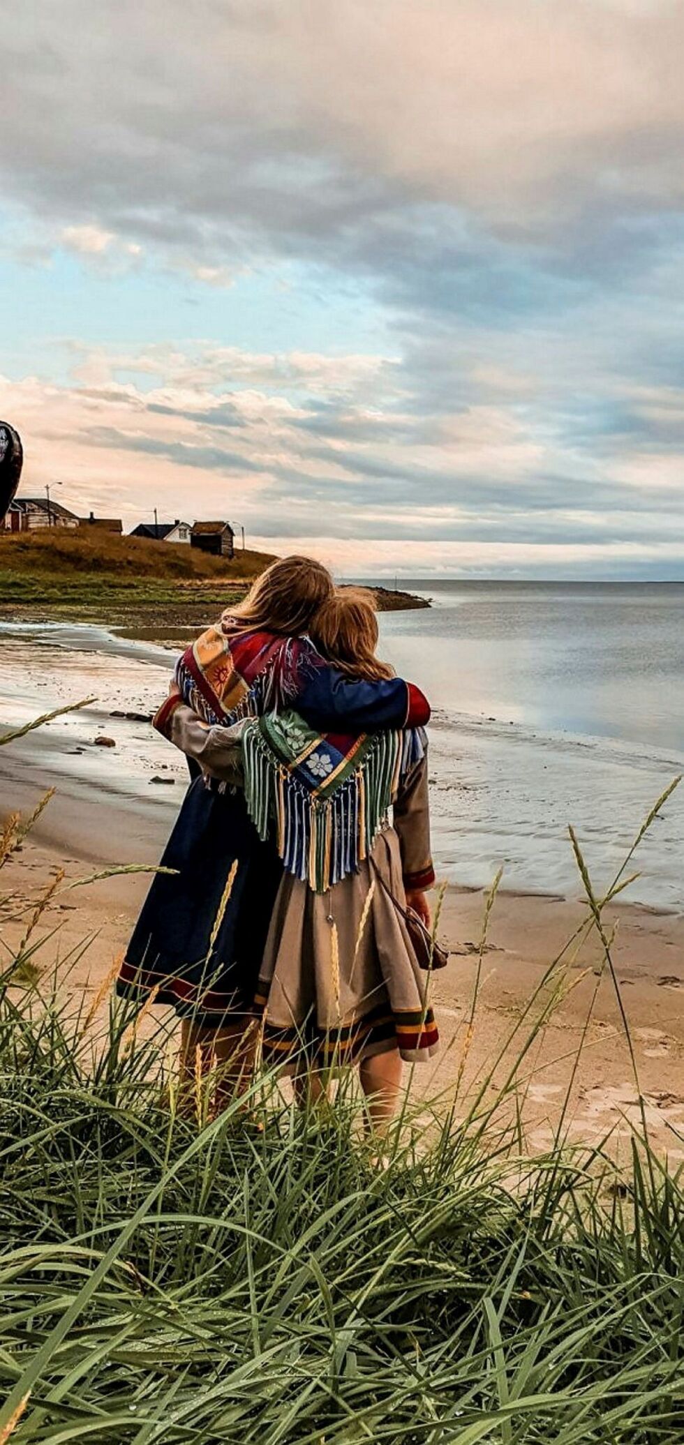 Lisa og Kajsa i sine Sør-Varanger kofter. Jentene ønsker ikke være anonyme, men har bevisst valgt å ikke vise ansiktene sine på deres bilder. De ønsker heller at vi skal legge merke til naturen, og ikke ha fokus på menneskene.
 Foto: Máinnas