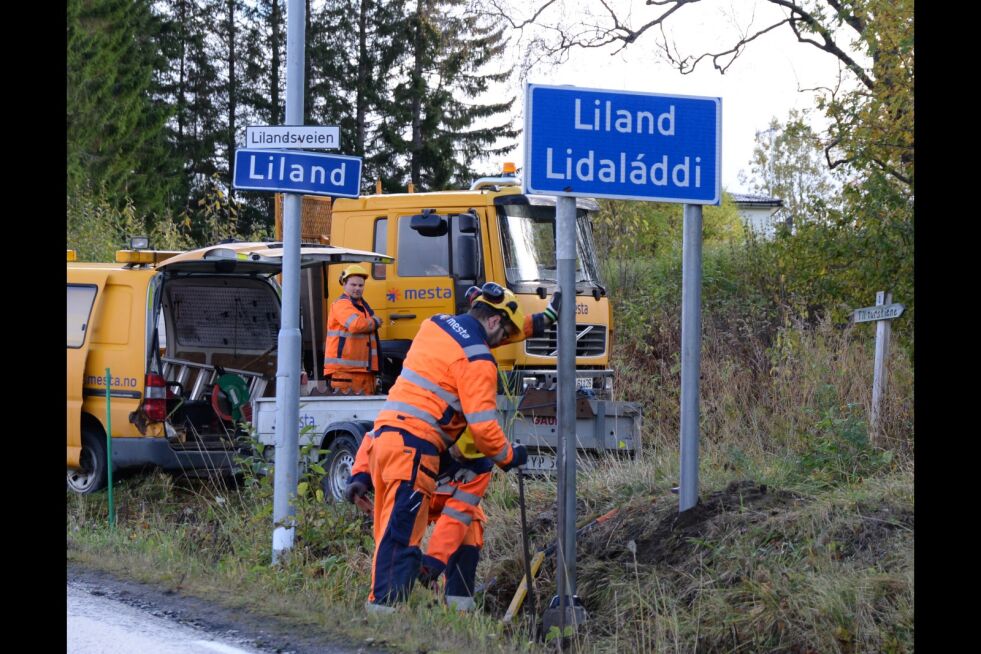 Her setter Mesta-gutta opp det tospråklige skinnende nye skiltet for Liland-Lidaláddi i Evenes kommune. Det gamle skiltet på lyktestolpen kan pensjoneres.
 Foto: Steinar Solaas