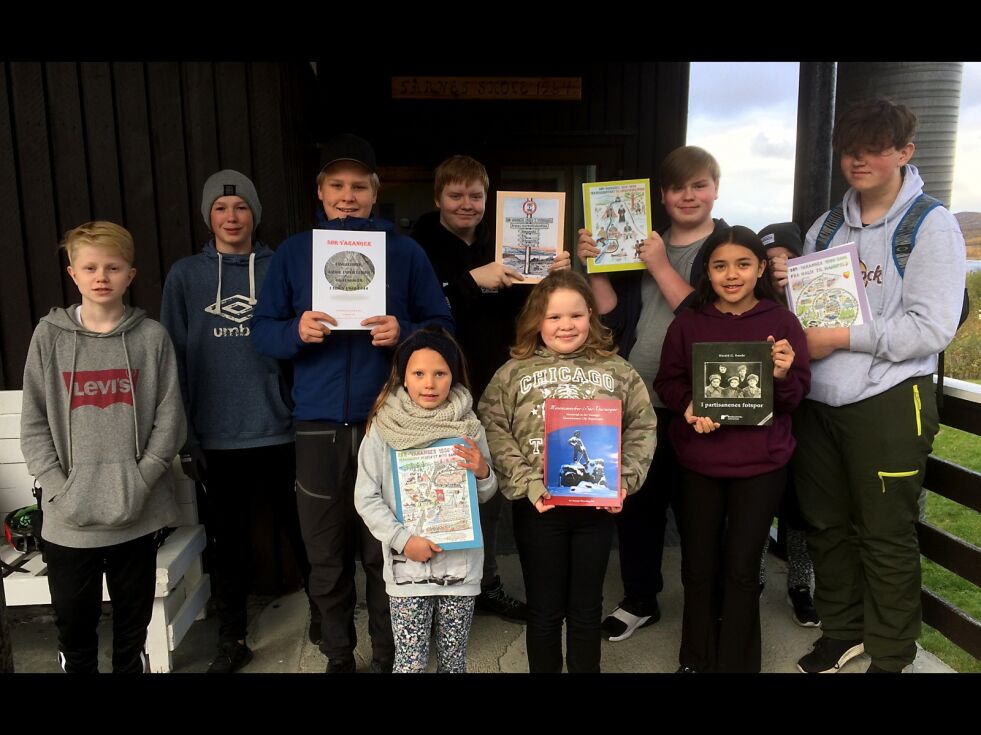 Her poserer (bak fra venstre) Henrik, Bjørn Robin, Magnus, Mats, Christian og Tobias samt (foran) fra venstre: Elle, Ida og Marita med bokgaven fra historielaget og Sunde foran skolen i Jarfjord.
 Foto: Privat