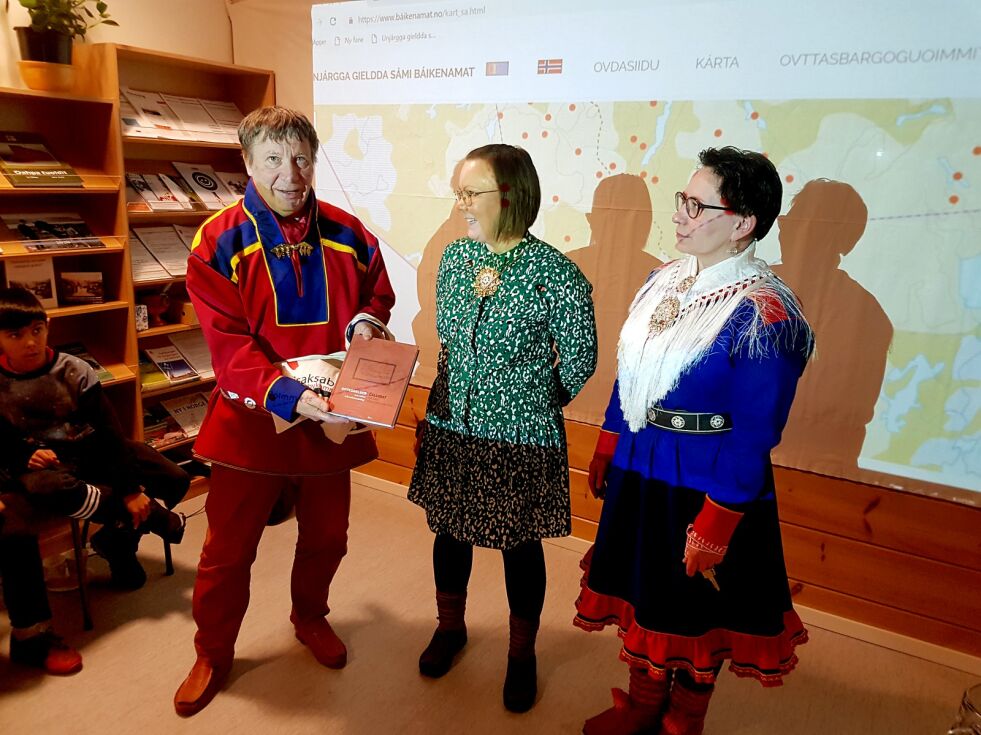 Fra lanseringen av appen og nettsiden. Prosjektleder Yngve Johansen (til venstre) fra Tana får overrakt gave av Sini Rasmus (i midten) og Nina Margit fra Isak Saba senteret i Varangerbotn, for ledelsen av jobben med å samle inn 3.000 samiske stedsnavn i Nesseby.
 Foto: Tom Hardy